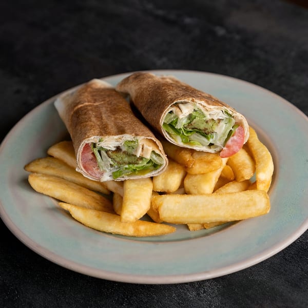 Two La Marra falafel wraps with lettuce and tomato, served with golden french fries on a plate.
