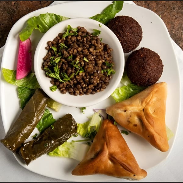 A La Marra platter with lentil salad, falafel, stuffed grape leaves, and spinach pies.
