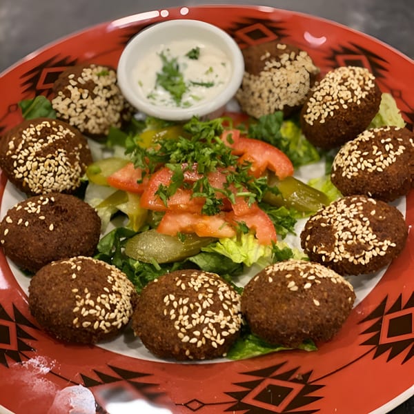 La Marra's falafel platter with sesame-crusted falafel, fresh salad, and a side of white sauce.